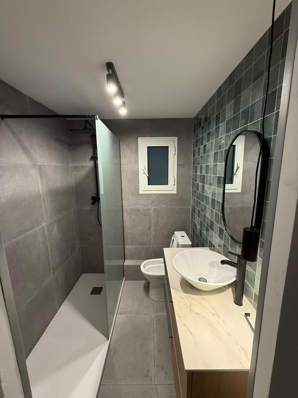 Baño reformado con azulejo verde